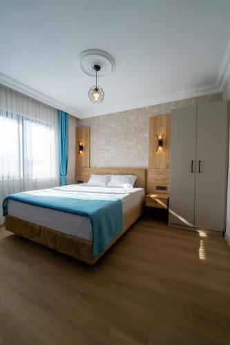 a bedroom with a large bed with a blue blanket at Coastline Orange Hotel in Antalya