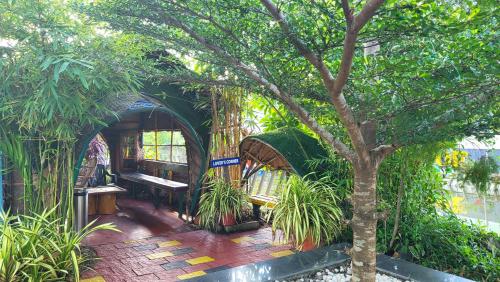 a tree sitting next to a building with a bench at Bell Farms and Resorts in Munroe Island