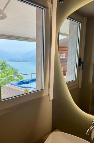 a bathroom with a window with a view of the ocean at Esprit D'Hotel Panoramico in Fonteno