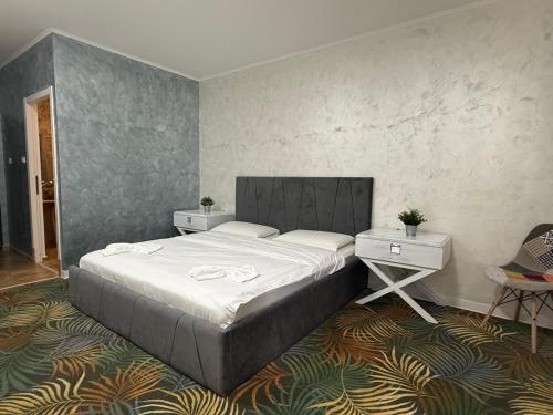 a bedroom with a large bed and two tables at Pensiunea Raya in Dubova