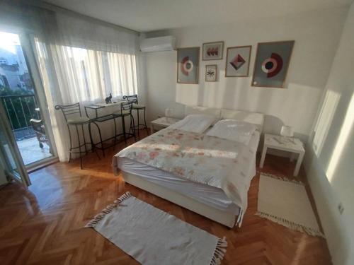 a bedroom with a bed and a table in it at Centar apartman - gradski trg in Gornji Milanovac