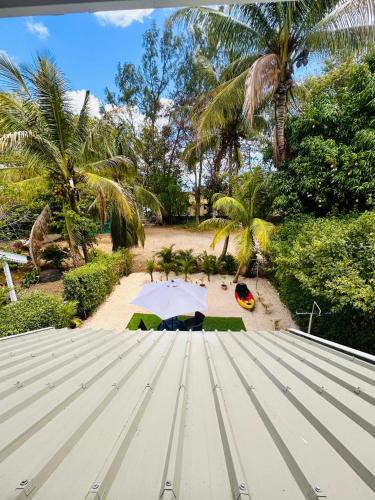 a view of a beach with a tent and palm trees at Sands Beach LUX Villa Flic en Flac in Flic-en-Flac