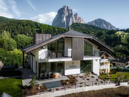 ein Haus mit einem Berg im Hintergrund in der Unterkunft Anna Lodges Dolomites in St. Christina in Gröden