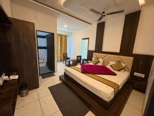 a bedroom with a bed with a red pillow on it at Shere Punjab Hotel & Restaurant in Ābu Road