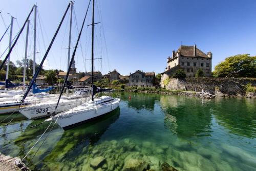 two boats are docked in the water in front of a castle at Le Clos du Léman I Charme & Sauna in Anthy