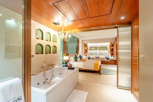 a bathroom with a bed and a tub in a room at Sayaji Indore in Indore