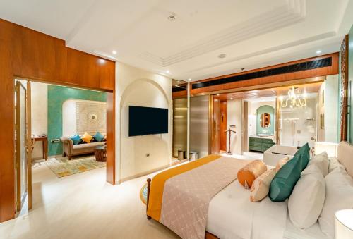 a bedroom with a large bed and a living room at Sayaji Indore in Indore
