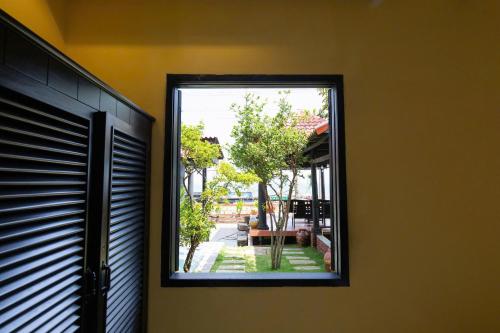 a window of a house with a view of a yard at Sabina Boutique Hotel & Villa Mui Ne in Mui Ne