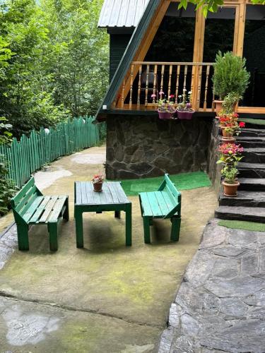 a patio with two benches and a table and a balcony at Riverhush cabin in Machakhlispiri