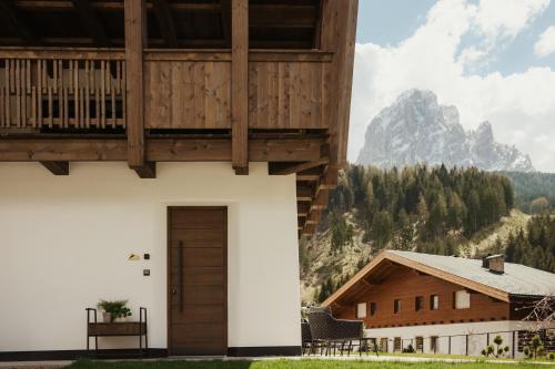 a building with a wooden door and a mountain at Apartments Villa Sofia in Santa Cristina in Val Gardena