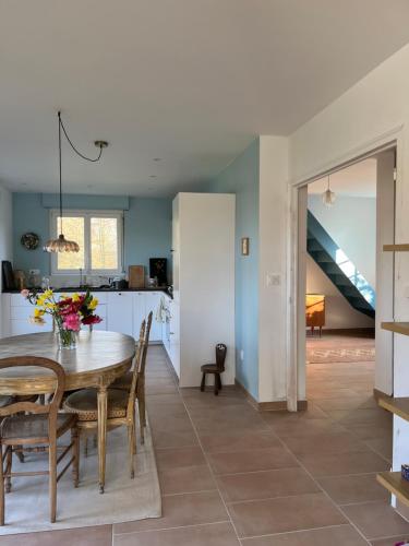 une cuisine et une salle à manger avec une table et des chaises dans l'établissement Maison au bord de l'Aven, à Riec-sur-Bélon