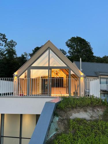 a house with large glass doors and a balcony at Casa Fux in Grassnitzberg