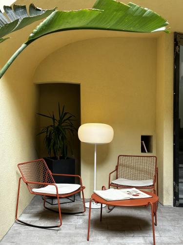 two chairs and a table under an umbrella at Ginevra Boutique Rooms - Palazzo Leosini - Residenze D'Epoca in LʼAquila