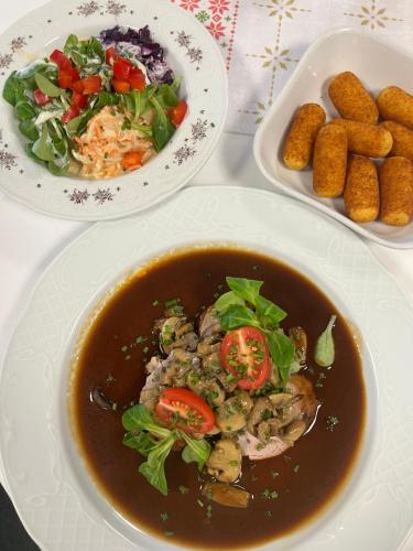 a table with two plates of food and a bowl of soup at Gasthof ALTE POST in Waldachtal