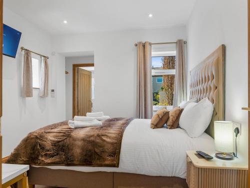 a bedroom with a large bed and a window at Newly Renovated Luxury Bungalow Pass the Keys in Ulverston
