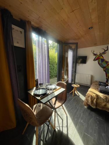 a room with a table and chairs and a bedroom at Gites d'Armor in Treguidel