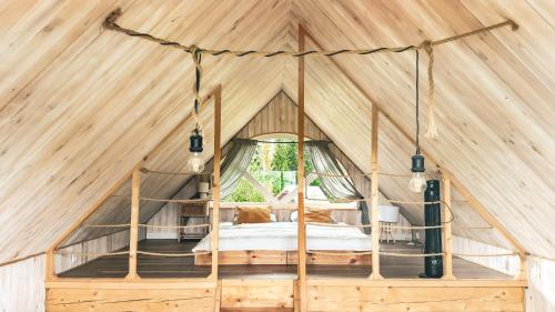 a bedroom in a wooden tent with a bed at Chatka Biesczadersko in Lutowiska