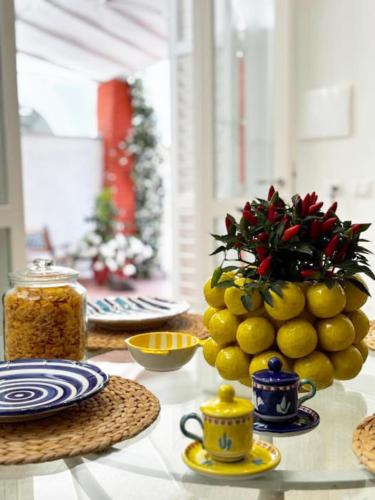 a table with a vase of lemons and a vase of christmas at Syrene Suites Sorrento in Piano di Sorrento