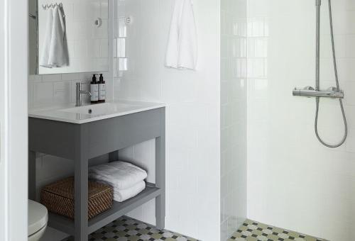 a white bathroom with a sink and a shower at Stay North Matri House Anni in Mathildedal
