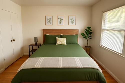 a bedroom with a green bed and a window at Spacious 3 Bedroom Home Near LA Close to Disneyland, Universal, Free Parking and Yard in Montebello