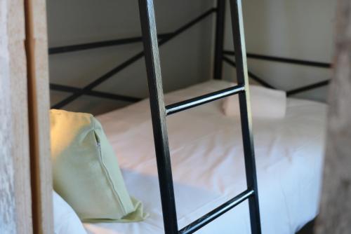 a ladder to a bunk bed with a bag on it at Norrqvarn Hotel & Resort by Vänerport in Lyrestad
