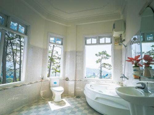 a bathroom with a tub and a toilet and a sink at Moon Villa Da Lat in Ấp Ða Lợi
