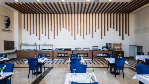 een restaurant met witte tafels en blauwe stoelen bij ANGEL'S PARK HOTEL in Denizli