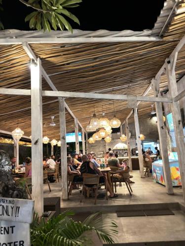 a group of people sitting at tables in a restaurant at Tiki bar and more in Nusa Lembongan