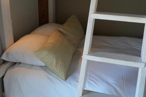 a bunk bed with two white pillows and a ladder at Norrqvarn Hotel & Resort by Vänerport in Lyrestad