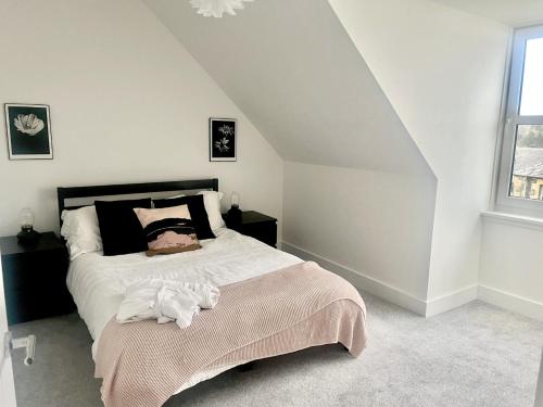 a bedroom with a bed with a black headboard at Cuan Flat - Oban in Oban