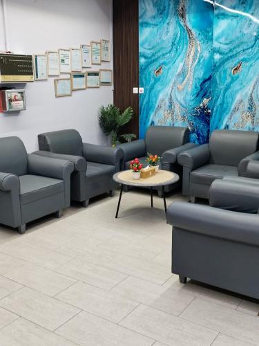 a waiting room with couches and a table and a painting at العييري للشقق المفروشة حائل1 in Hail