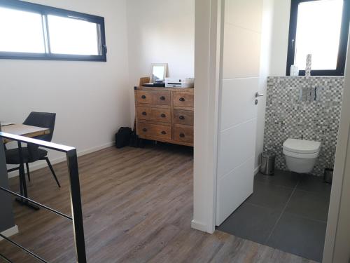 La salle de bains est pourvue de toilettes, d'une table et d'une armoire. dans l'établissement Bassin d'Arcachon maison cozi, à La Celle-sous-Gouzon