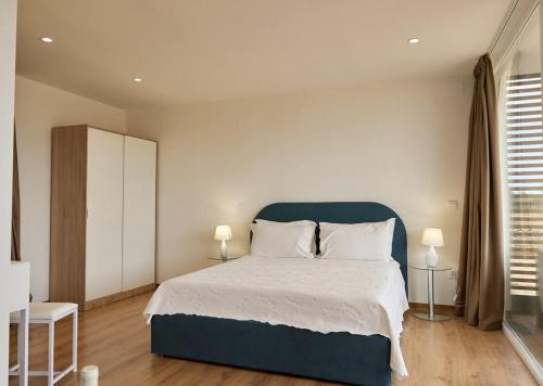 Un dormitorio con una cama grande y dos lámparas. en Borgo Rosso Terra, en Gallipoli