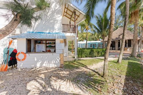 a food stand in front of a house with palm trees at Cocotiers Hotel – Mauritius in Port Louis