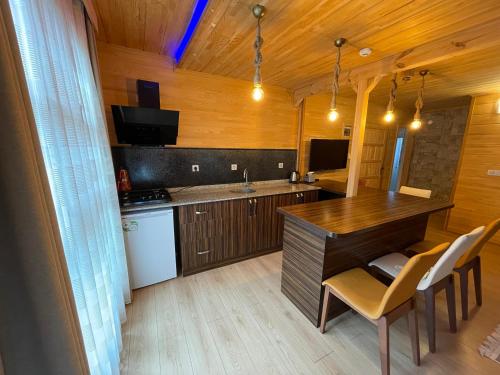 a kitchen with a wooden table and chairs in a room at Bavul Suite Hotel in Uzungol