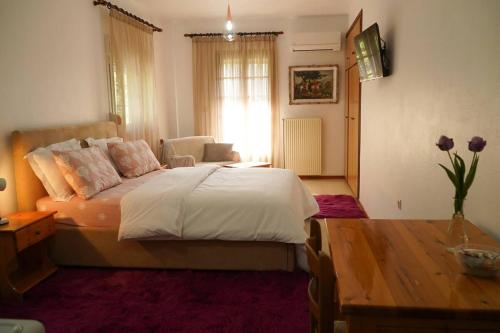 a bedroom with a large bed and a table at Iris Rooms Trigona in Trygón