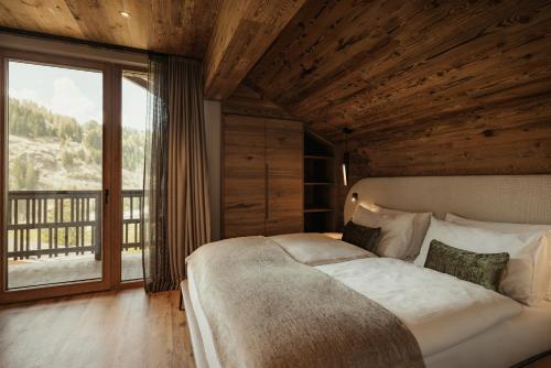 a bedroom with a large bed and a large window at Apartments Villa Sofia in Santa Cristina in Val Gardena