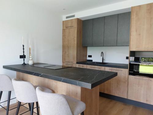 a kitchen with a black counter top and wooden cabinets at Strandcamping Valkenisse in Biggekerke