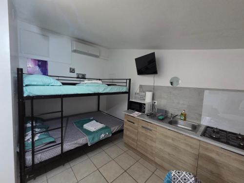 - une cuisine avec 2 lits superposés et un évier dans l'établissement Studio au calme avec piscine, à Baillargues