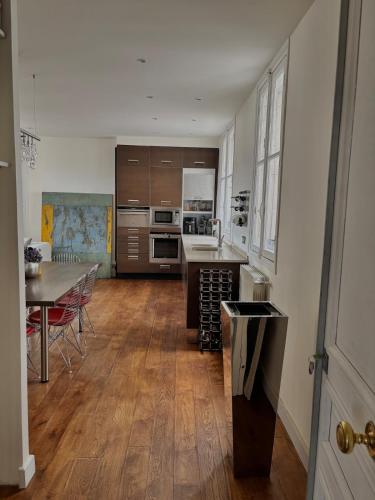 une grande cuisine avec une table et une salle à manger dans l'établissement Golden Triangle Champs-Élysées, à Paris