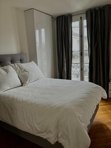 une chambre avec un grand lit blanc et une fenêtre dans l'établissement Golden Triangle Champs-Élysées, à Paris