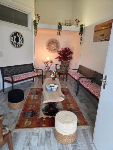 - un salon avec des bancs et une table dans l'établissement Maison spacieuse à Floirac avec jardin et terrasse, à Floirac