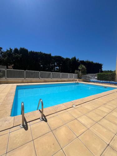 une piscine avec de l'eau bleue dans une cour dans l'établissement Studio 4-6 personnes à proximité de la plage, à Argelès-sur-Mer