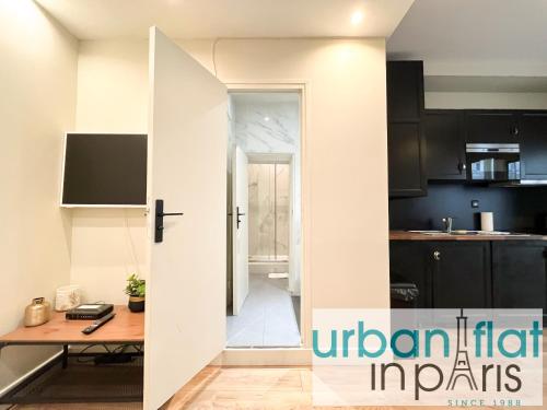 une cuisine avec une porte s'ouvrant sur une cuisine avec une table dans l'établissement 07 Best Flat of Grand Boulevard, à Paris