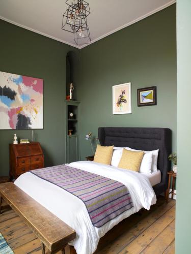 a bedroom with a large bed with green walls at The Royston in Llanbrynmair