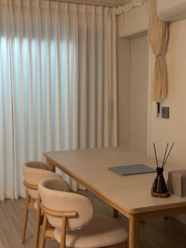 a dining room table with two chairs and a table at A peaceful rest stop on your journey in Busan