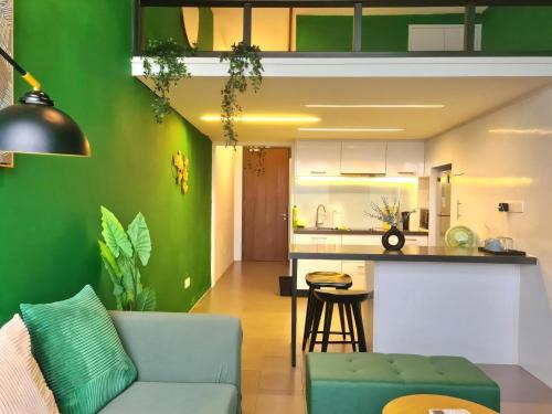 Una sala de estar y cocina con una pared verde. en The Establishment - Menara Teguh Bangsar, en Kuala Lumpur