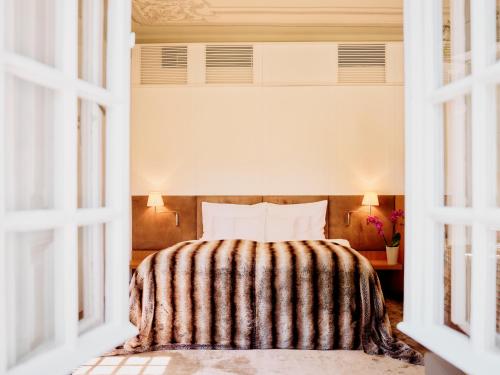 a bedroom with a bed with a striped blanket at TAUROA G'Schlössl Murtal in Großlobming