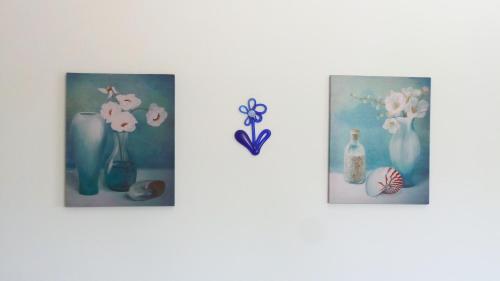 a group of three pictures of vases with flowers at Fiore Hill Sea View Studios in Vasilikos