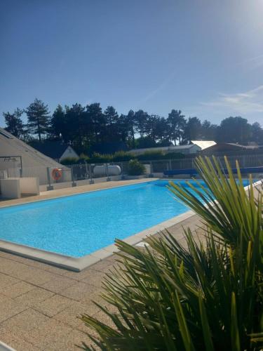une grande piscine bleue dans une cour dans l'établissement Chalet familial L'Abri Côtier, à Montmartin-sur-Mer